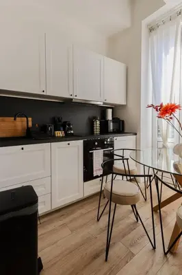 a kitchen with a glass table and white cabinets at Modern 3BR Duplex Near Nice Port & Old Town | By Airnest in Nice
