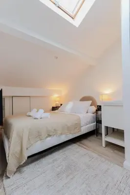 a white bedroom with a large bed with white pillows at Modern 3BR Duplex Near Nice Port & Old Town | By Airnest in Nice
