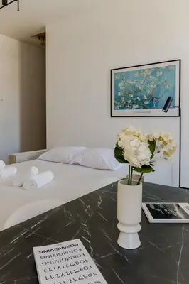 a white vase with flowers on a table next to a bed at Fancy 3BR Duplex Near Nice Port & Old Town | By Airnest in Nice