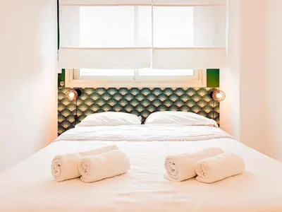 a bed with two towels on it with a window at Plage, Promenade & confort - Wifi, AC, 4 pers in Nice