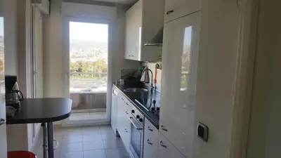 a kitchen with white cabinets and a sink and a window at Entire Condo in Nice in Nice