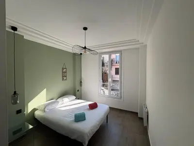 a bedroom with a bed and a window at 3-R bright, beach within 15 min walk in Nice