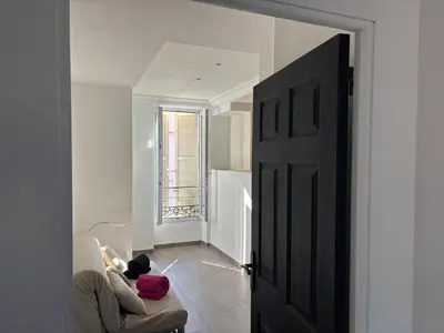 a person sitting on a couch in a living room with a stuffed animal at 3-R bright, beach within 15 min walk in Nice