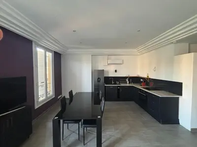 a large kitchen with a black table and chairs at 3-R bright, beach within 15 min walk in Nice