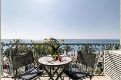 a table and chairs on a balcony with the ocean at Sea View - Lovely Studio Promenade des Anglais in Nice