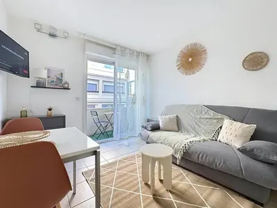 a living room with a couch and a table at Studio calme avec balcon proche du port de Nice in Nice