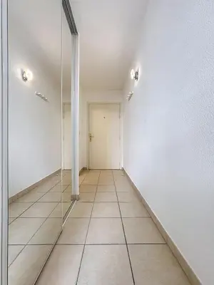 an empty room with a hallway with a glass door at Studio calme avec balcon proche du port de Nice in Nice