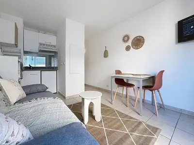 a living room with a couch and a table with chairs at Studio calme avec balcon proche du port de Nice in Nice
