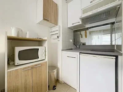 a small kitchen with a microwave and a sink at Studio calme avec balcon proche du port de Nice in Nice