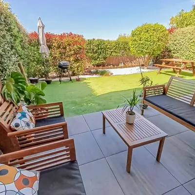 a patio with two benches and a table and a lawn at Fabron studio et Résidence de Luxe avec Piscine in Nice