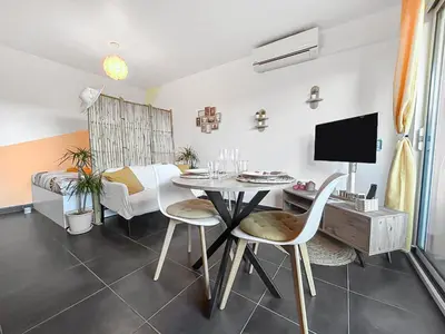 a dining room with a table and chairs and a tv at Fabron studio et Résidence de Luxe avec Piscine in Nice