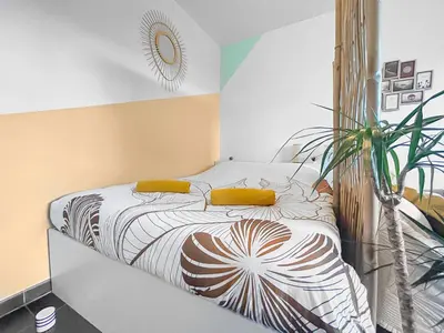 a bedroom with a bed with yellow pillows and a plant at Fabron studio et Résidence de Luxe avec Piscine in Nice