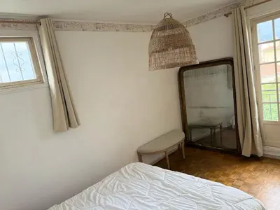 a bedroom with a mirror and a bed and a chair at maison de charme piscine au bord de mer in Cagnes-sur-Mer
