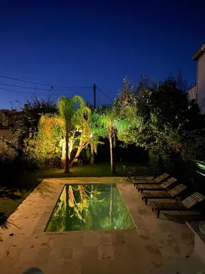 a group of benches and a pool of water at night at maison de charme piscine au bord de mer in Cagnes-sur-Mer