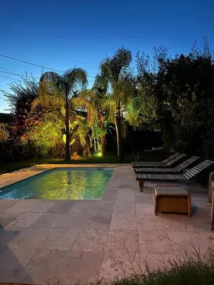 a swimming pool with two benches next to a park at maison de charme piscine au bord de mer in Cagnes-sur-Mer