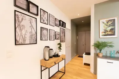 a hallway with a white wall with framed pictures at #34 Lamartine Central 3 Bdrs AC balcony 10mins walk to old town in Nice