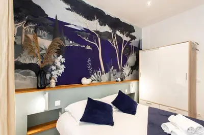 a bedroom with a large painting above a bed at #34 Lamartine Central 3 Bdrs AC balcony 10mins walk to old town in Nice
