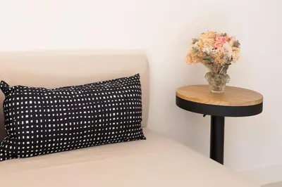 a black and white pillow and a vase with flowers on a table at #35 Suite Carlone 5min from the beach AC & Terrace in Nice