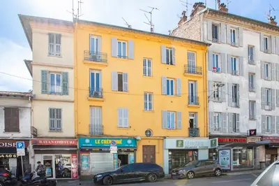 a yellow building with cars parked in front of it at #35 Suite Carlone 5min from the beach AC & Terrace in Nice