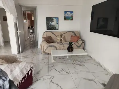 a living room with a couch and a table on a marble floor at Spacieux 3 chambres et balcon in Nice