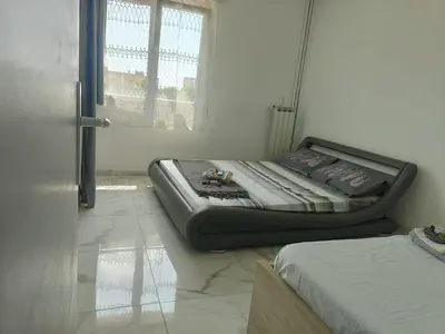 a room with a bed sitting on the floor next to a window at Spacieux 3 chambres et balcon in Nice