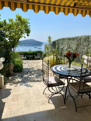 a table and chairs with a vase on a patio at Studio Bellevue in Villefranche-sur-Mer