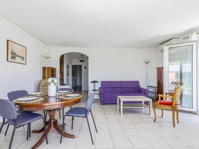 a living room with a table and a purple couch at Apartment Baie Azur by Interhome in Nice