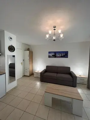 a living room with a couch and a table at Sunny studio with Terrace in Nice
