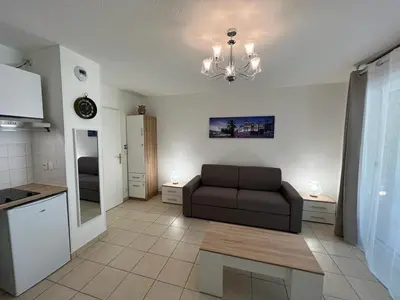 a living room with a couch and a kitchen at Sunny studio with Terrace in Nice