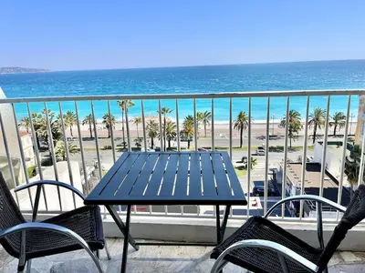 a table and chairs on a balcony overlooking the beach at Spacious 2P Terrace with sea view in Nice