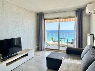 a living room with a couch and a television and a balcony at Spacious 2P Terrace with sea view in Nice