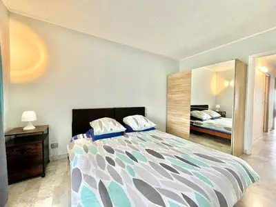 a bedroom with a large bed and a mirror at Spacious 2P Terrace with sea view in Nice