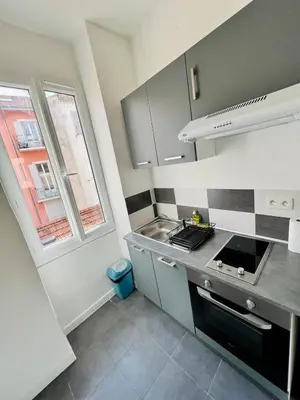 a kitchen with a stove and a sink and a window at Charmant studio moderne équipé à Nice in Nice