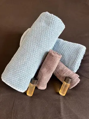 two bottles of essential oils next to a towel at Charmant studio moderne équipé à Nice in Nice