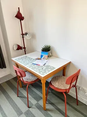 a table with two chairs and a table and a lamp at Charmant studio moderne équipé à Nice in Nice