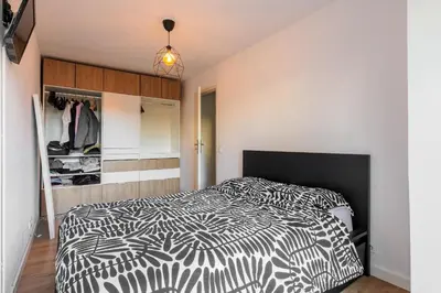 a bedroom with a black and white bed and a closet at Grand 2 pieces et belle terrasse ensoleillee in Nice