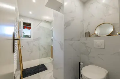 a white bathroom with a toilet and a mirror at Grand 2 pieces et belle terrasse ensoleillee in Nice