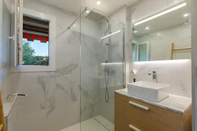 a white bathroom with a sink and a shower at Grand 2 pieces et belle terrasse ensoleillee in Nice