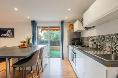 a kitchen with white cabinets and a counter top at Grand 2 pieces et belle terrasse ensoleillee in Nice