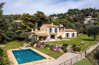 an estate with a swimming pool in front of a house at Magnifique villa avec vue mer panoramique in Nice