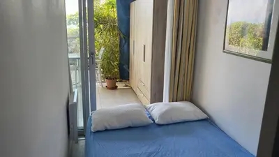 a small bed in a room with a window at Costa Plana apartment with terrace and sea view in Cap d'Ail