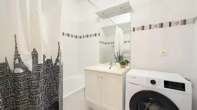 a bathroom with a washing machine and a bath tub at nice two rooms in Nice