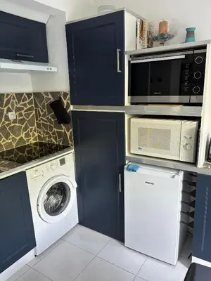 a kitchen with a washing machine and a microwave at Agréable appartement à Beaulieu sur mer à 300 métres des commerces et de la mer in Beaulieu-sur-Mer