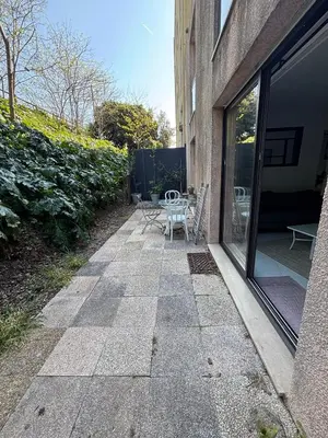 a patio with a table and chairs next to a building at Agréable appartement à Beaulieu sur mer à 300 métres des commerces et de la mer in Beaulieu-sur-Mer