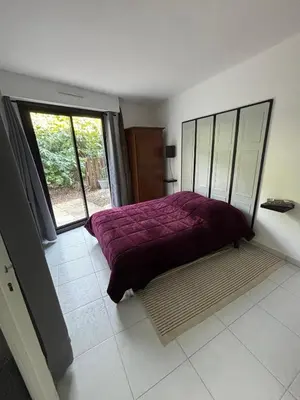 a bedroom with a purple bed and a window at Agréable appartement à Beaulieu sur mer à 300 métres des commerces et de la mer in Beaulieu-sur-Mer