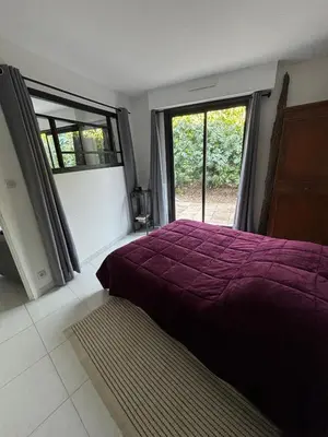 a bedroom with a purple bed and a window at Agréable appartement à Beaulieu sur mer à 300 métres des commerces et de la mer in Beaulieu-sur-Mer