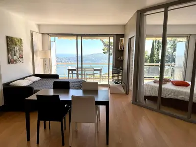 a bedroom with a bed and a table and a dining room at Les Jardins de Villefranche in Villefranche-sur-Mer