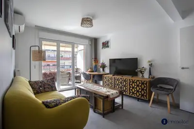 a living room with a yellow couch and a television at Air-conditioned apartment near Libération district in Nice