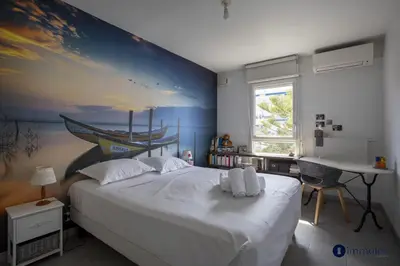a bedroom with a large white bed and a desk at Air-conditioned apartment near Libération district in Nice