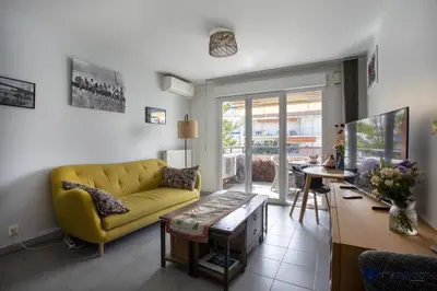 a living room with a yellow couch and a table at Air-conditioned apartment near Libération district in Nice